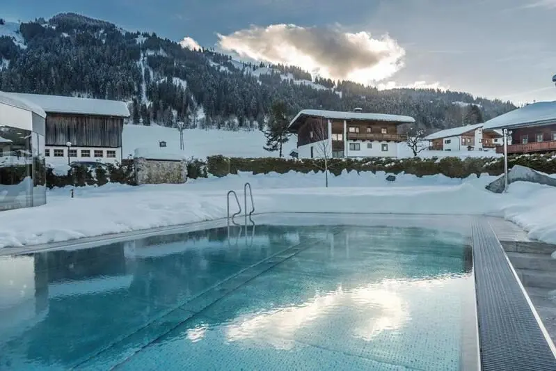 Buitenzwembad van Hotel Wastlhof in een besneeuwd landschap