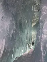 Blue ice cave with icicles and layered ice