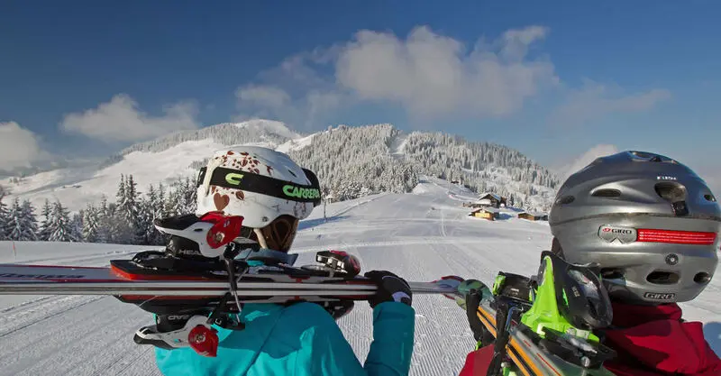 Skiërs op de zonnige pistes van het Markbachjoch boven Niederau
