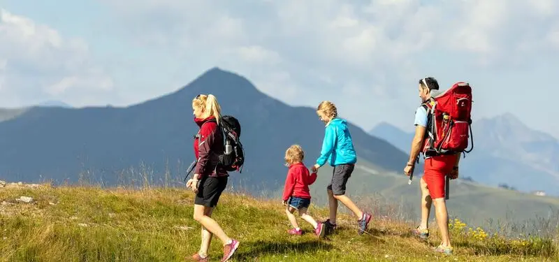 Gezin wandelt over een bergweide in de Wildschönau