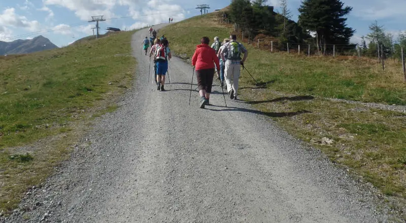 Wandelaars op een brede bergweg bij een stoeltjeslift